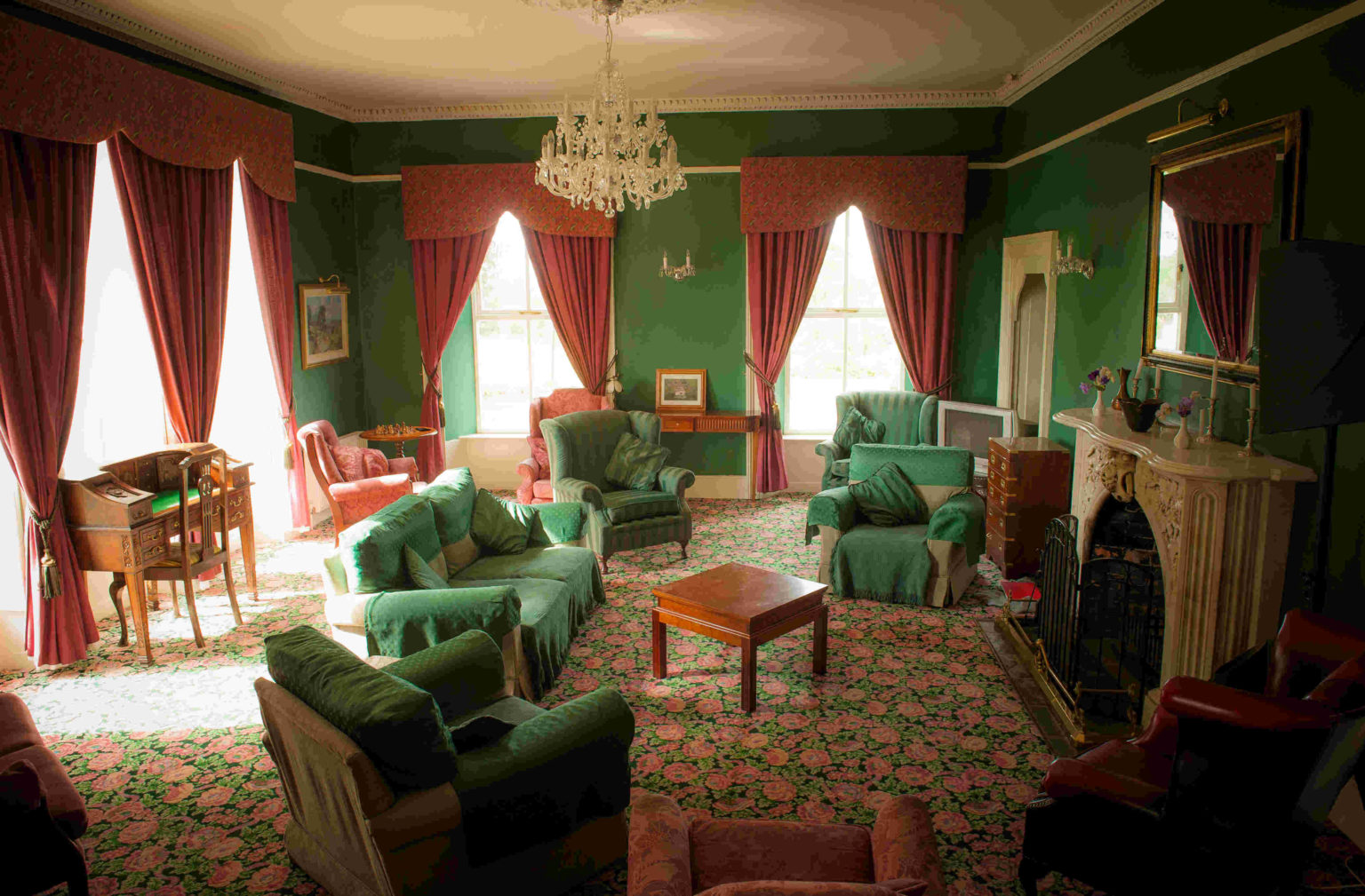 One of the manor's two lounges, with a marble fireplace and chandelier.